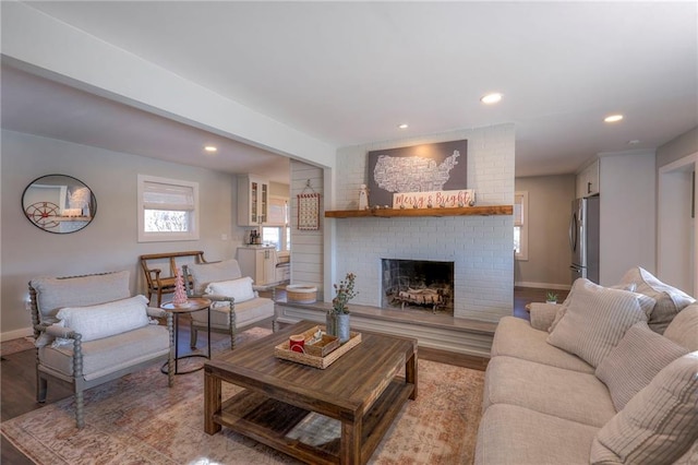 living room with a fireplace and light wood-type flooring