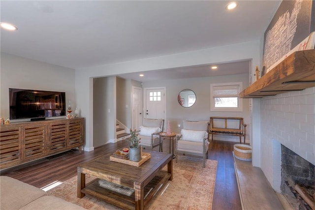 living room featuring hardwood / wood-style floors and a brick fireplace