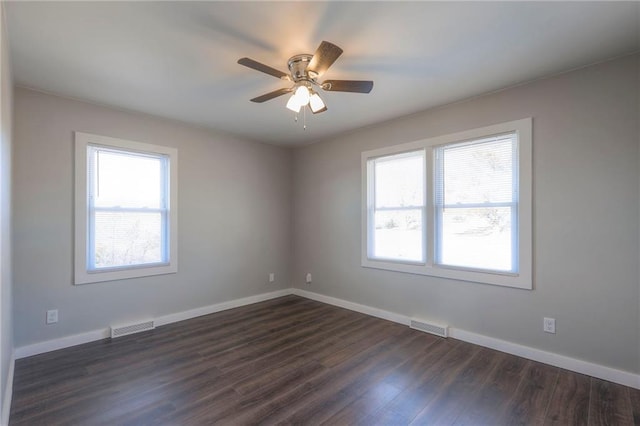 unfurnished room with dark hardwood / wood-style flooring, ceiling fan, and a healthy amount of sunlight