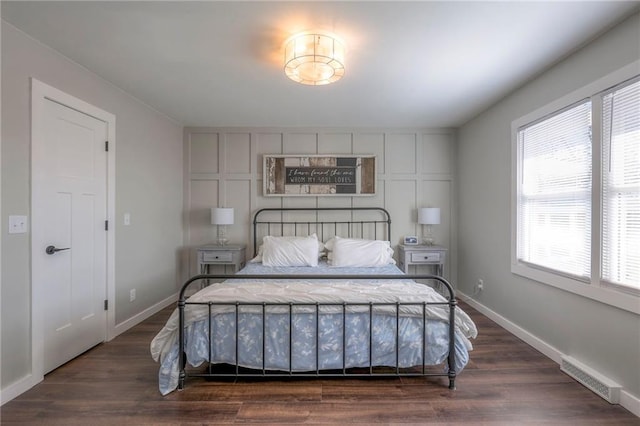 bedroom featuring dark hardwood / wood-style floors and multiple windows