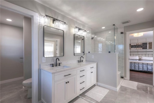 bathroom with tiled shower, vanity, and toilet