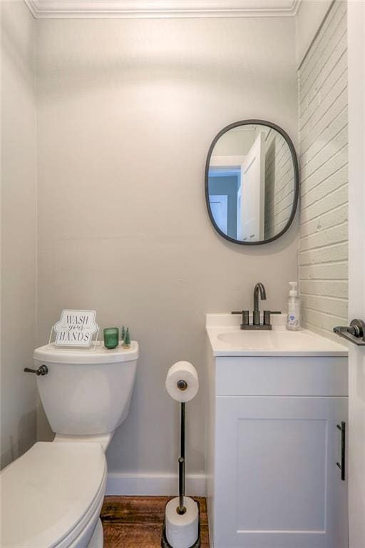 bathroom featuring hardwood / wood-style floors, vanity, ornamental molding, and toilet