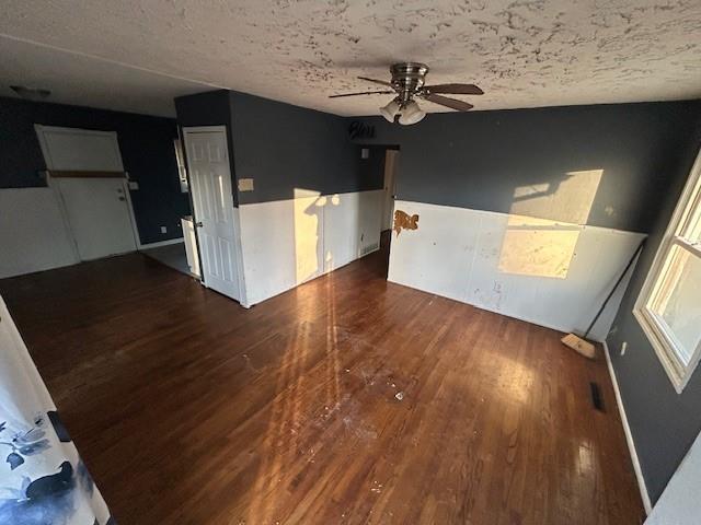 spare room featuring ceiling fan, dark hardwood / wood-style flooring, and a textured ceiling