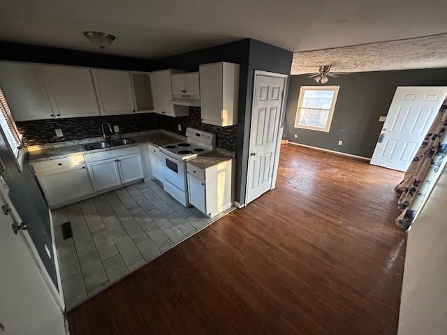 kitchen with white cabinetry, sink, ceiling fan, wood-type flooring, and electric stove