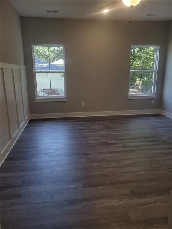 unfurnished room with ceiling fan and dark wood-type flooring