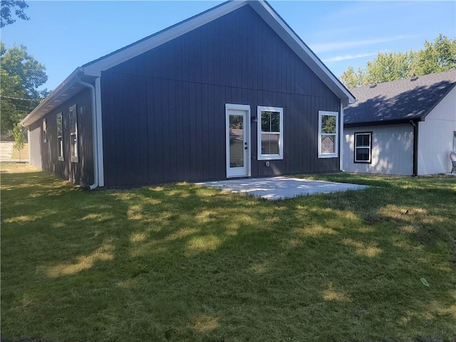 back of property with a yard and a patio