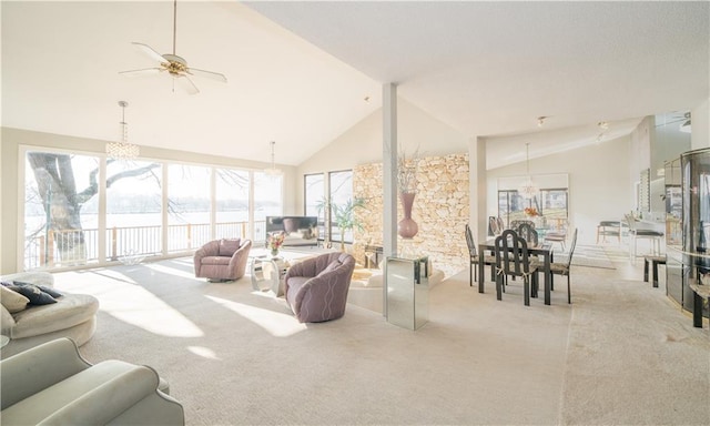 living room with ceiling fan, a healthy amount of sunlight, light colored carpet, and vaulted ceiling