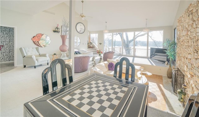 carpeted dining area with ceiling fan and lofted ceiling