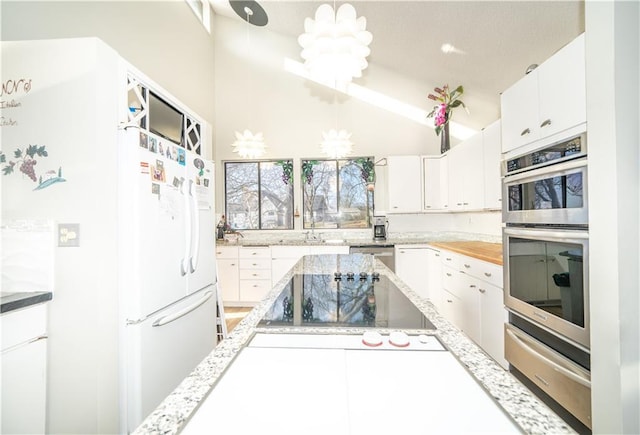 kitchen with white cabinetry, stainless steel appliances, and hanging light fixtures