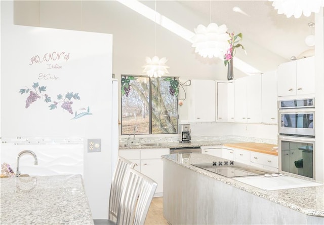 kitchen featuring white cabinets, decorative light fixtures, and stainless steel appliances