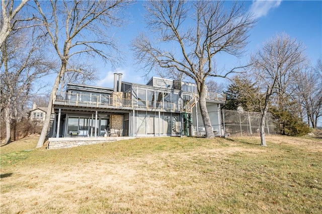 rear view of house featuring a lawn and a wooden deck