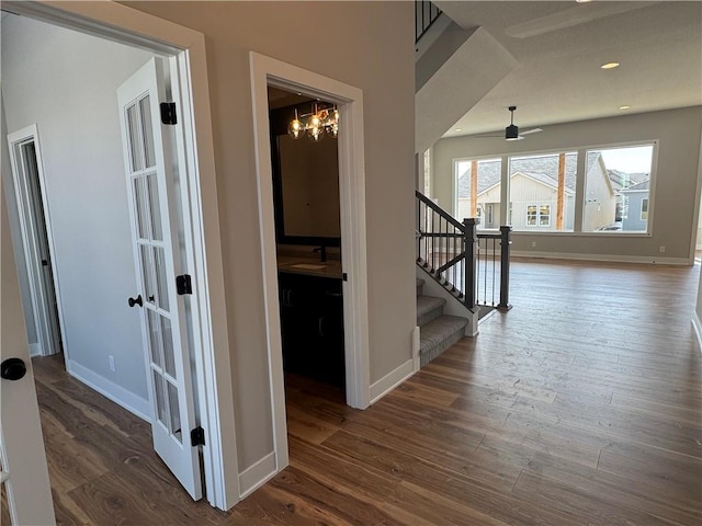 hall featuring an inviting chandelier, sink, and dark wood-type flooring