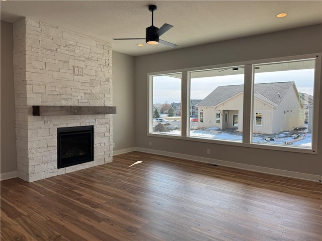 unfurnished living room featuring ceiling fan, hardwood / wood-style floors, and a fireplace