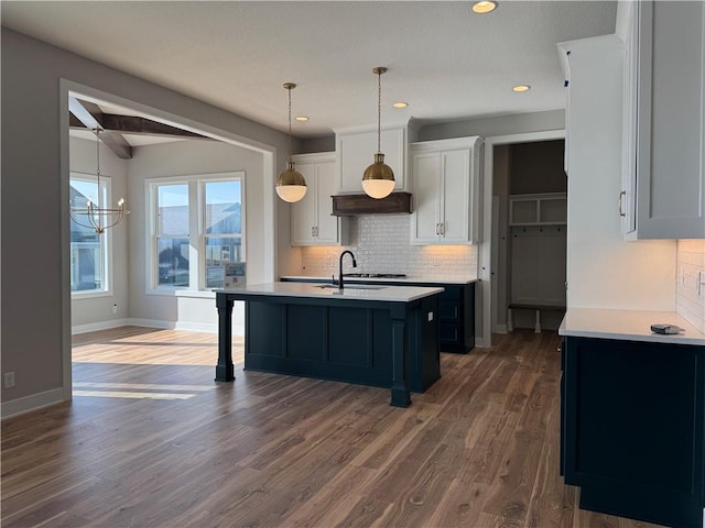 kitchen with dark hardwood / wood-style floors, decorative light fixtures, white cabinetry, sink, and beam ceiling