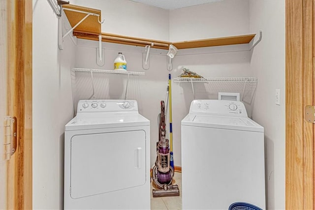 washroom with washing machine and dryer and light tile patterned floors