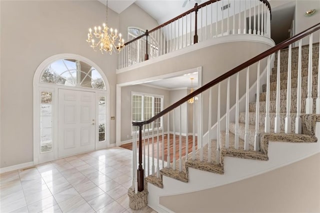 foyer entrance featuring light tile patterned floors, a high ceiling, and an inviting chandelier