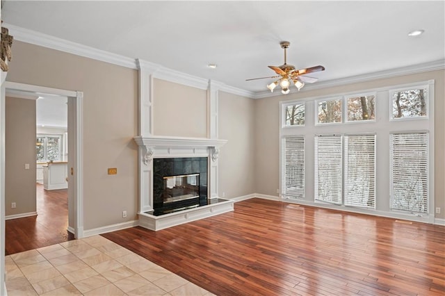 unfurnished living room with crown molding, plenty of natural light, and a high end fireplace