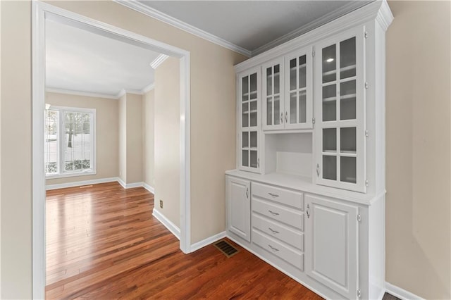 hallway with dark hardwood / wood-style flooring and ornamental molding