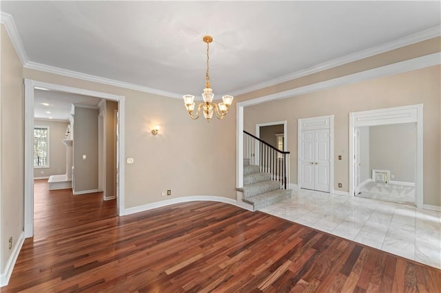 spare room featuring a notable chandelier, light hardwood / wood-style flooring, and crown molding