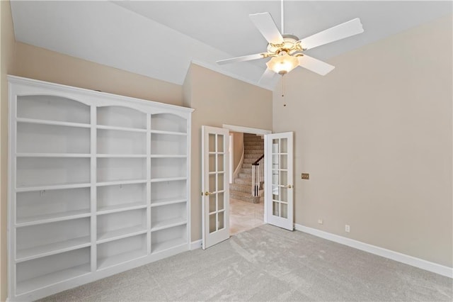 carpeted empty room featuring ceiling fan, french doors, and lofted ceiling