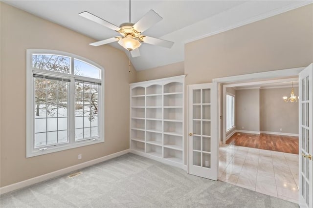 carpeted spare room with french doors, vaulted ceiling, and ceiling fan with notable chandelier