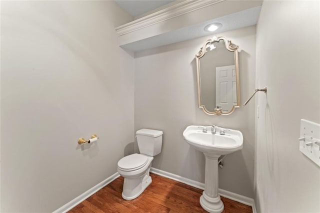 bathroom with hardwood / wood-style flooring and toilet