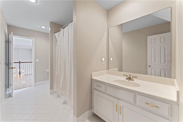 bathroom with tile patterned flooring, vanity, and walk in shower