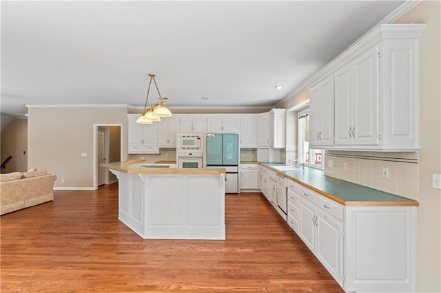 kitchen with a kitchen island, white appliances, and white cabinetry