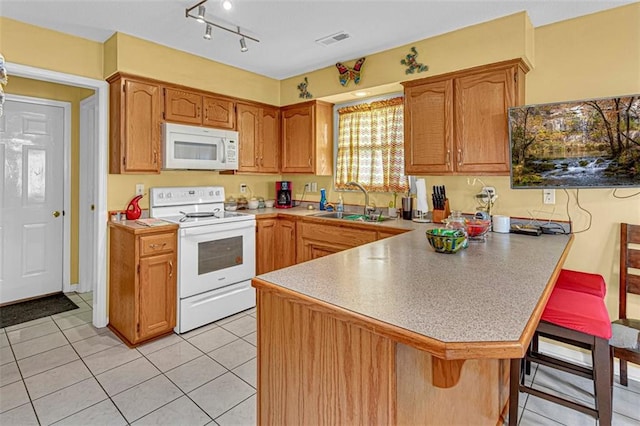 kitchen featuring kitchen peninsula, a breakfast bar, white appliances, sink, and light tile patterned flooring