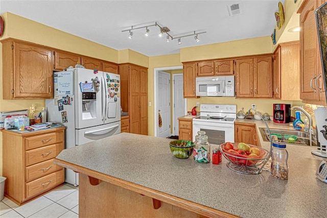 kitchen featuring kitchen peninsula, light tile patterned flooring, white appliances, and sink