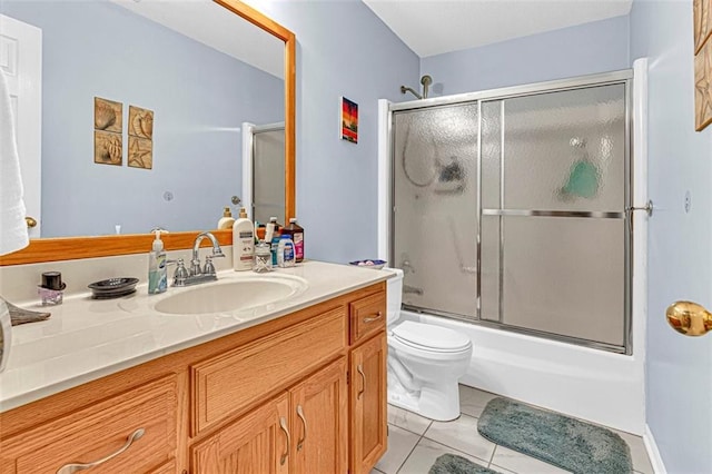 full bathroom featuring toilet, vanity, tile patterned floors, and bath / shower combo with glass door