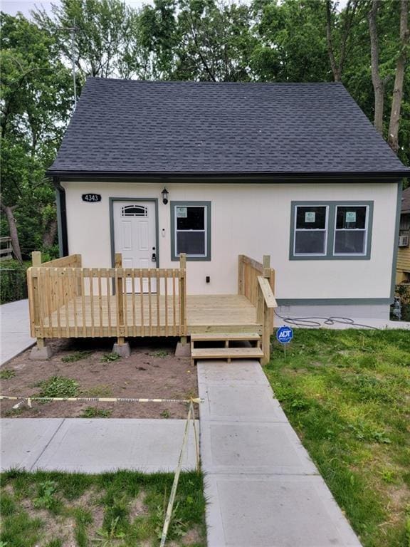 view of front of house featuring a front lawn and a wooden deck