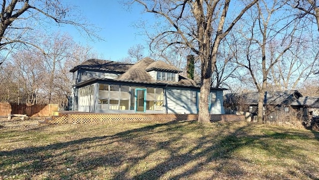 back of property featuring a yard and a sunroom