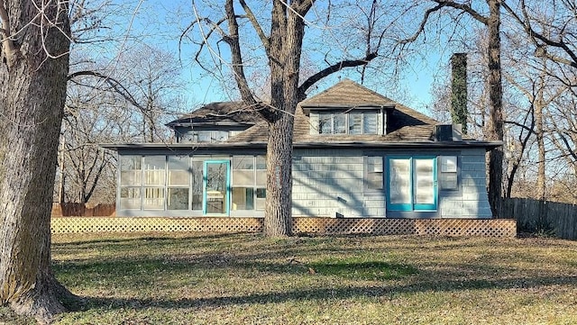 back of house with a lawn and a sunroom