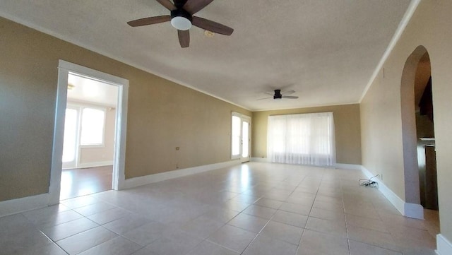 spare room featuring ceiling fan, plenty of natural light, and light tile patterned floors