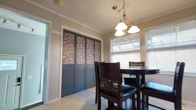 dining room with crown molding, light tile patterned floors, and a chandelier