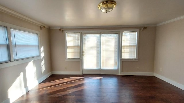 spare room featuring dark hardwood / wood-style flooring, a healthy amount of sunlight, and ornamental molding