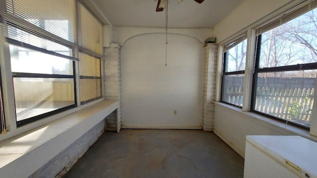 unfurnished sunroom with ceiling fan