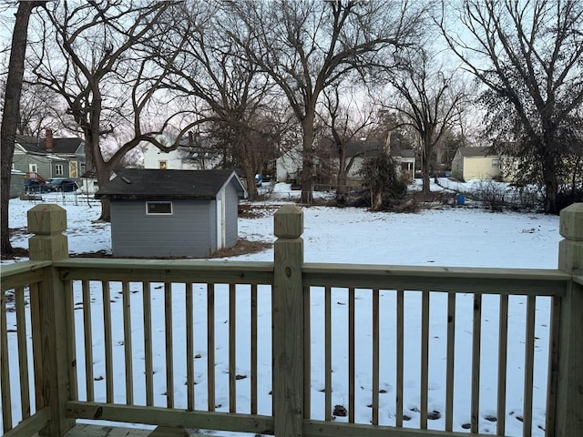 snow covered deck featuring a shed