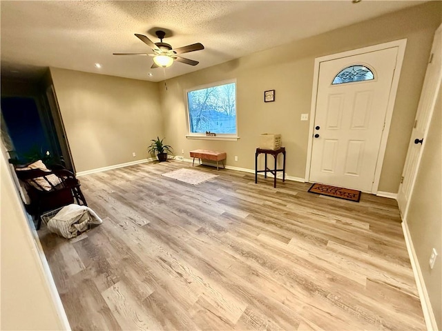 entrance foyer featuring ceiling fan, light hardwood / wood-style floors, and a textured ceiling