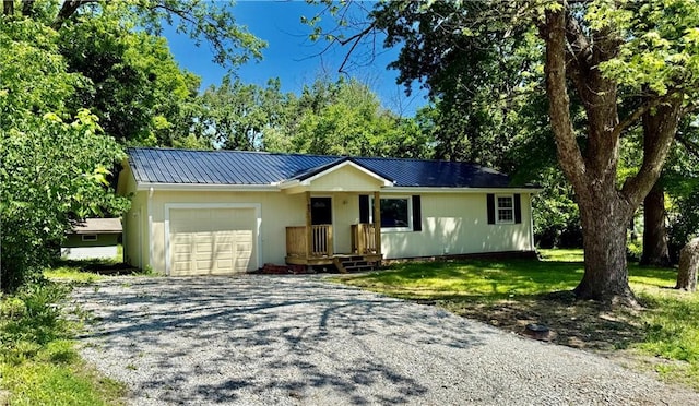 513 S Thornton St, Richmond, MO 64085 - ranch-style house featuring an attached garage, gravel driveway, metal roof, and a front lawn