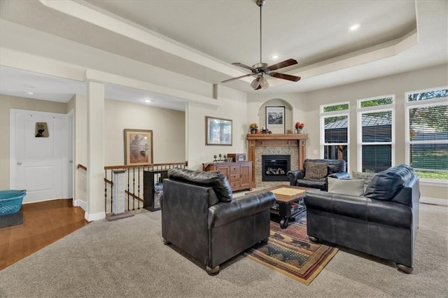 living room featuring hardwood / wood-style floors, a tray ceiling, and ceiling fan