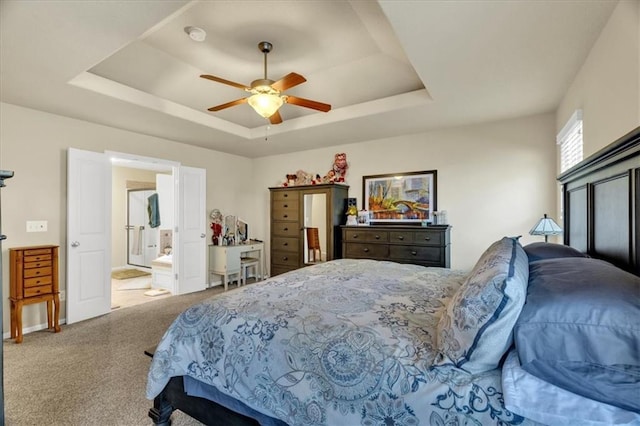 carpeted bedroom with a raised ceiling and ceiling fan