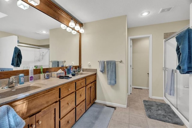 bathroom featuring tile patterned flooring, vanity, and an enclosed shower