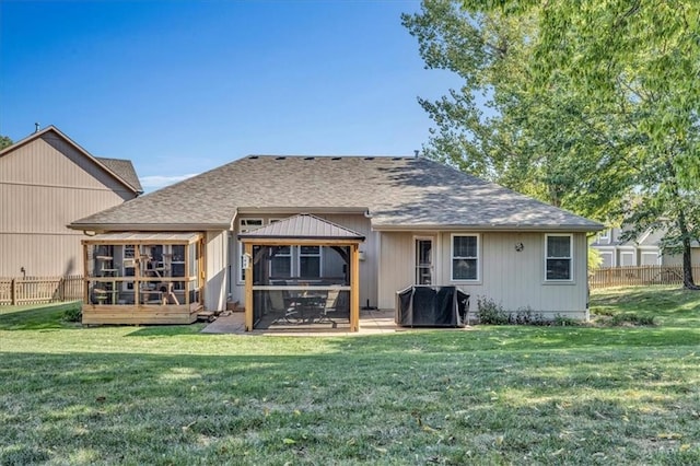 back of property with a sunroom, a patio area, and a yard