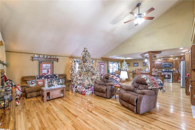 living room with ceiling fan, light hardwood / wood-style flooring, and high vaulted ceiling