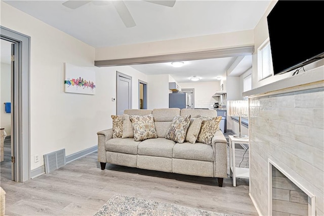 living room with ceiling fan and light hardwood / wood-style flooring