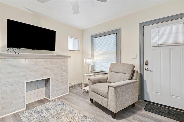 living area with ceiling fan and light hardwood / wood-style floors