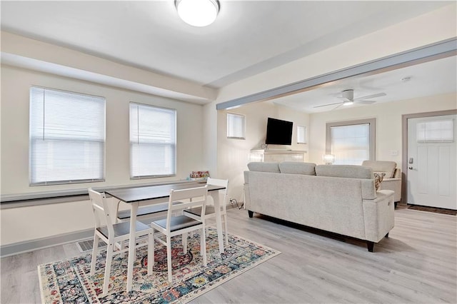 living room with ceiling fan and light hardwood / wood-style flooring