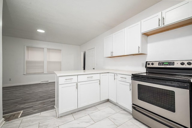 kitchen featuring kitchen peninsula, white cabinetry, and stainless steel electric range